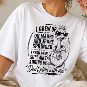 Könnte beinhalten: Weißes T-Shirt mit einem schwarzen Aufdruck eines Straußes mit Sonnenbrille und Kapuzenpullover. Der Text auf dem Shirt lautet: "I GREW UP ON MAURY AND JERRY SPRINGER. I KNOW WHEN SH*T AIN'T ADDING UP. Don't play with me."