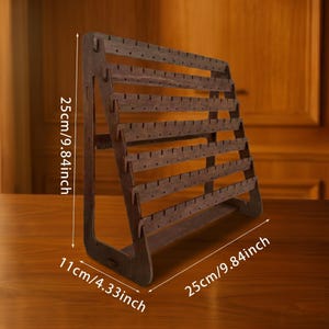 May include: A wooden earring display stand, 9.84 inches tall and wide, with multiple rows of holes for hanging earrings. The stand is 4.33 inches deep and is made of dark brown wood. The display is angled for visibility.