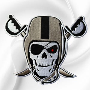 May include: An embroidered patch featuring a skull wearing a football helmet with a black stripe, an eye patch, and a single red eye. Two crossed swords are positioned behind the helmet, all outlined in white thread on a black background.
