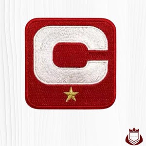 May include: Embroidered patch with a red square background. A large white letter "C" is centered, with a gold star below. The patch is likely for clothing or accessories.