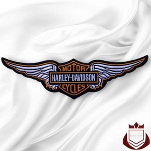 May include: An embroidered Harley-Davidson patch featuring a central shield with the text MOTOR HARLEY-DAVIDSON CYCLES in orange and white, flanked by two stylized light blue wings with black outlines, all set against a dark background.