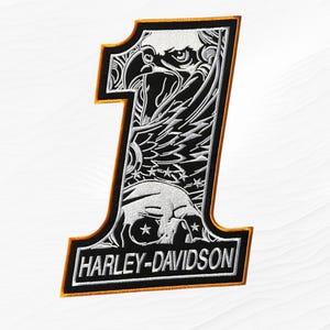 May include: An embroidered patch in the shape of the number one with a black and white design featuring an eagle head, a skull, and stars. The text HARLEY-DAVIDSON is stitched in white at the bottom, outlined with a thin orange border.
