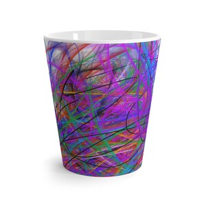 May include: A tall, white ceramic latte mug with a vibrant, abstract design. The design features a chaotic arrangement of colorful lines in shades of purple, blue, green, orange, and black, creating a dynamic and artistic look. The mug has a smooth, glossy finish.