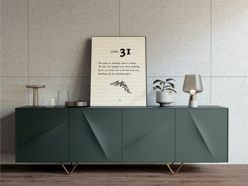 May include: A framed print with a black frame and a white background. The print features a black and white illustration of a bat with the text "october 31" and "The nights are drawing in, winter is coming. The life of the pumpkin moon will be blooming. By the rise of the crow on the face of the year, something will die, something will appear."