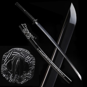 Op de afbeelding: Een zwart katana-zwaard met een gebogen lemmet, gedetailleerde handgreep en schede. De schede heeft decoratieve zilveren accenten en een gedetailleerd ontwerp. Het zwaard wordt tegen een zwarte achtergrond getoond.
