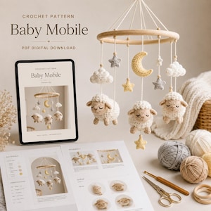 Op de afbeelding: Een haakpatroon als PDF-download voor een babymobiel met een houten ring en daaraan gehaakte schaapjes, sterren en een halve maan. De set bevat een tablet met het patroon, gedrukte instructies, bollen garen en een schaar.