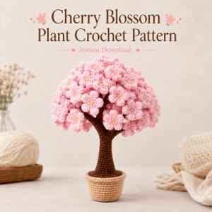 May include: A crocheted cherry blossom plant in a small pot. The tree has a brown trunk and a full canopy of pink flowers with yellow centres. The text "Cherry Blossom Plant Crochet Pattern" is at the top of the image.