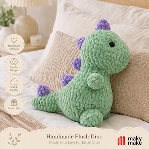 Peut inclure: Une peluche dinosaure crochetée vert clair avec une finition en fil épais et texturé. Le dinosaure présente une rangée de petites pointes violettes arrondies le long du dos et de la queue, ainsi qu'un œil noir visible sur le côté de la tête.