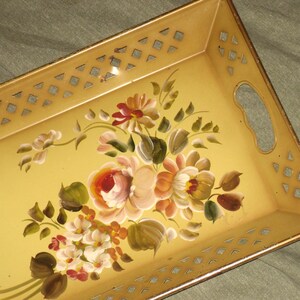 May include: Rectangular serving tray with a yellow background and a floral design. The tray has a gold-colored rim and cut-out diamond shapes along the edges. The floral design features pink, white, and orange roses.