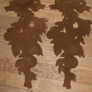 May include: A pair of brown wooden wall decor pieces shaped like stylized floral designs.