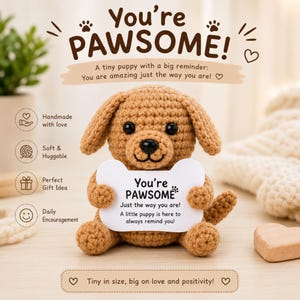 Puede incluir: Un cachorro marrón tejido a ganchillo sosteniendo un letrero con forma de hueso que dice "You're PAWSOME!". La imagen incluye texto que dice "Hecho a mano con amor", "Suave y abrazable", "Idea de regalo perfecta" y "Aliento diario".