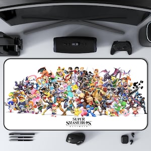 May include: A white rectangular mouse mat with a black border, displaying a vibrant graphic of characters from Super Smash Bros. Ultimate. The game's logo is at the bottom of the mat.