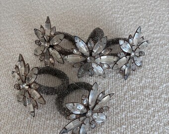 Set of 5 vintage-style decorative napkin rings featuring intricate clear crystal or glass flower arrangements and beaded bands.