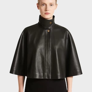 Zwart leren cropped capejack, minimalistische hoogsluitende jas in designerstijl