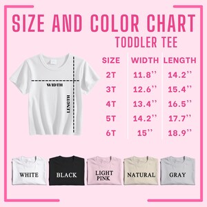 Op de afbeelding: Een wit peuter-T-shirt met een maat- en kleurentabel. De tabel geeft maten 2T tot 6T, met breedte- en lengtematen in inches. Beschikbare kleuren zijn wit, zwart, lichtroze, naturel en grijs.