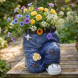 Dekorativ blomkruka i form av vintagejeans med skor
