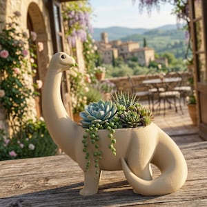 May include: A beige dinosaur-shaped planter filled with succulents. The planter has a long neck and tail, with a small opening for the plants. The succulents are various shades of green and blue, with trailing vines. The planter is on a wooden surface.