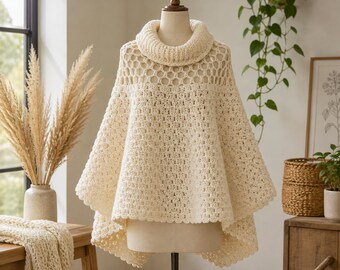 May include: A cream-colored crochet poncho featuring a high cowl neckline, a decorative honeycomb-style openwork pattern around the upper chest and shoulders, and a dense, textured stitch pattern throughout the main body of the garment.