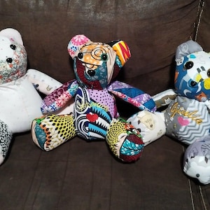 Peut inclure: Trois ours en peluche faits à la main avec des motifs de tissu uniques. L'un a une tête florale et un corps blanc, un autre est un patchwork de tissus colorés, et le troisième a un motif bleu et gris avec le mot "Guess" sur sa poitrine.