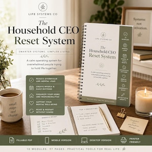 Może przedstawiać: Planer spiralny zatytułowany The Household CEO Reset System z białą okładką i oliwkowozielonym panelem bocznym. Planer jest otwarty na stronie cotygodniowego resetu, obok znajduje się złoty długopis, mała beżowa karteczka samoprzylepna i kubek.