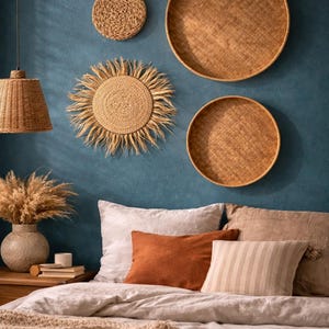 Peut inclure: Une chambre avec un mur bleu canard orné de décorations murales tissées. Le lit est composé d'une literie aux tons neutres, d'oreillers et d'un plaid texturé. Une suspension en osier est suspendue au-dessus du lit.
