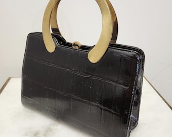 Bolso de mano vintage de los años 50 con textura de piel de cocodrilo negra y asa dorada de Block.