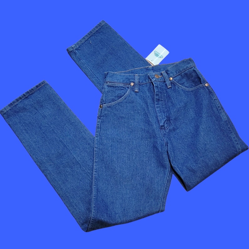 May include: A pair of blue denim jeans with a straight leg fit. The jeans have a classic five-pocket design and a button fly.