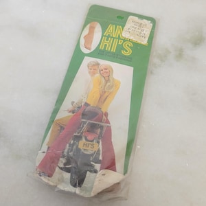 May include: A vintage package of ankle high stockings with the text "ankle high one size 1st quality" and "ain't hi's" on the front. The package features a couple riding a motorcycle with the text "hi's" on the back of the motorcycle.