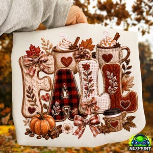 May include: A white sweatshirt featuring a graphic print of the word FALL, where each letter is styled with autumn textures like cable knit, red and black buffalo plaid, and floral patterns, accented with mugs, pumpkins, and bows.