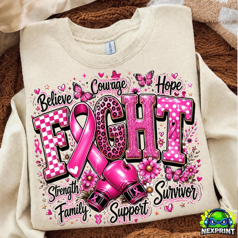 May include: A cream-colored sweatshirt featuring a graphic with the word FIGHT in large, pink, patterned letters. A pink awareness ribbon replaces the letter I, and two pink boxing gloves are below. Text includes Believe, Courage, Hope, Strength, Family, Support, and Survivor, with butterflies and flowers.