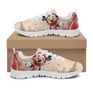 K&ouml;nnte beinhalten: Paar Turnschuhe mit wei&szlig;er Sohle und Minnie Mouse-Design. Die Schuhe haben einen beigefarbenen Hintergrund mit einem rosa und roten Blumenmuster und einem Cartoon-Bild von Minnie Mouse in einem rosa Kleid. Die Turnschuhe werden auf einem braunen Karton pr&auml;sentiert.