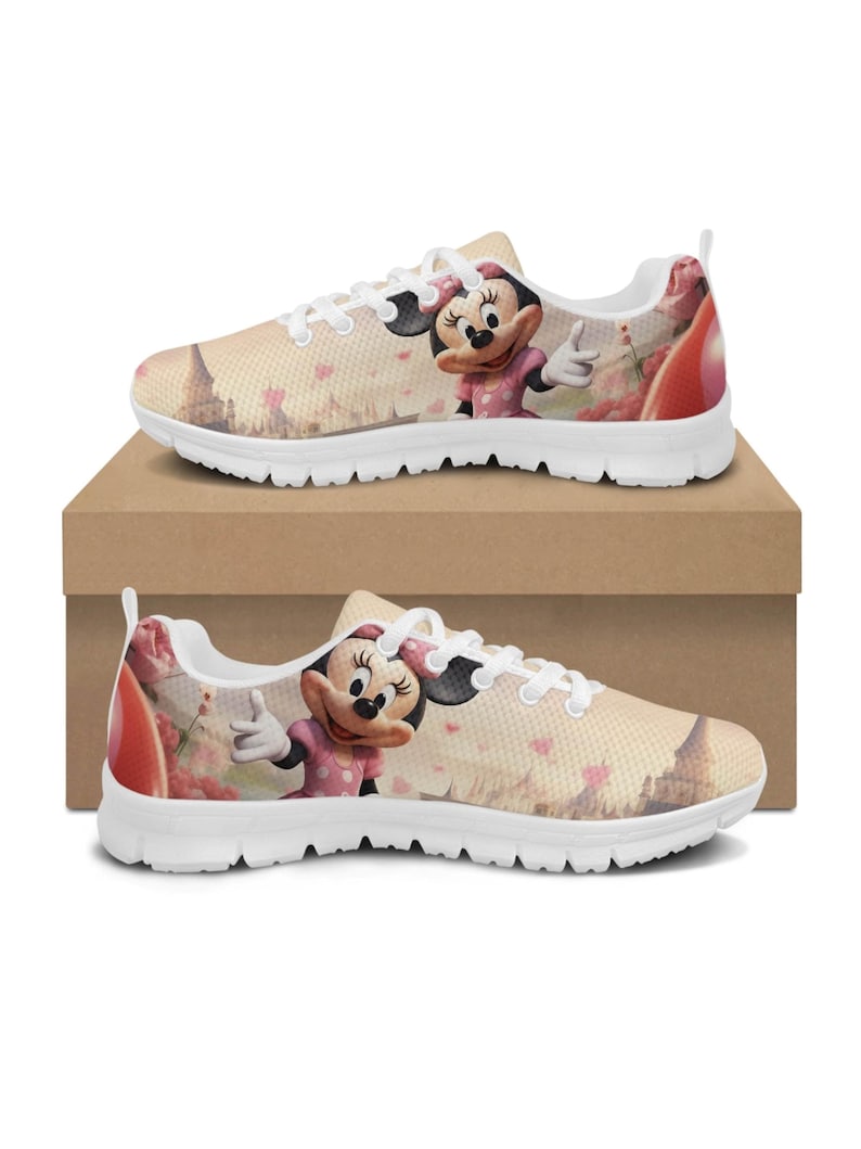 K&ouml;nnte beinhalten: Paar Turnschuhe mit wei&szlig;er Sohle und Minnie Mouse-Design. Die Schuhe haben einen beigefarbenen Hintergrund mit einem rosa und roten Blumenmuster und einem Cartoon-Bild von Minnie Mouse in einem rosa Kleid. Die Turnschuhe werden auf einem braunen Karton pr&auml;sentiert.
