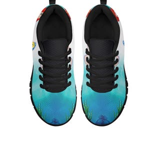 May include: A white ceramic mug with a black handle and the text "But First, Coffee" in a bold, black font. The mug is displayed on a white surface, highlighting its simple design.