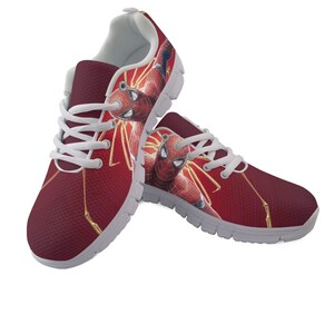 K&ouml;nnte beinhalten: Paar weinrote Sportschuhe mit einem Spider-Man-Motiv. Die Schuhe haben wei&szlig;e Schn&uuml;rsenkel, ein wei&szlig;es Innenfutter und eine graue Sohle. Das Spider-Man-Bild ist rot, blau und gelb. Die Schuhe sind bequem und stilvoll.