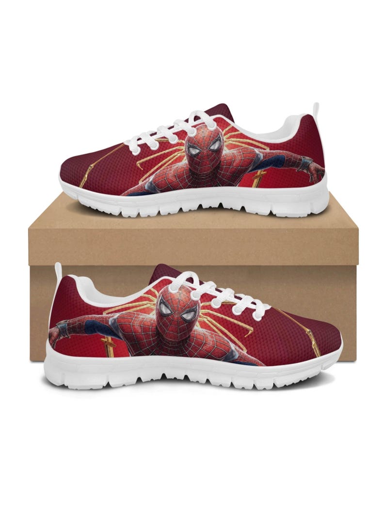 K&ouml;nnte beinhalten: Rote und wei&szlig;e Sportschuhe mit einem Spider-Man-Motiv. Die Schuhe haben ein rotes Mesh-Obermaterial mit einem Spider-Man-Bild sowie wei&szlig;e Schn&uuml;rsenkel und Sohlen. Die Schuhe werden auf einem braunen Karton pr&auml;sentiert.