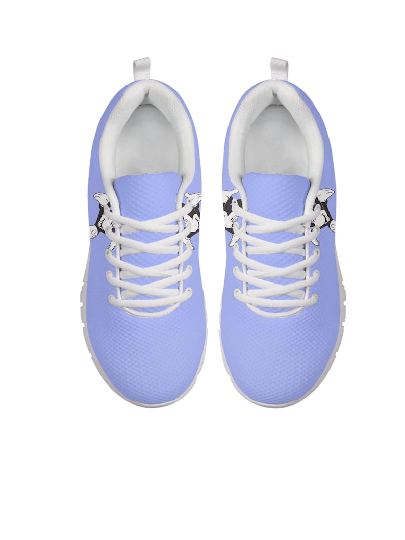 May include: Light blue trainers with white laces and soles. The shoes have a black and white cartoon cow design on the sides. These trainers are designed for comfort and style, suitable for everyday wear.