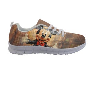 Pu&ograve; includere: Un paio di scarpe sportive con un'immagine a cartoni animati di Topolino. Le scarpe hanno uno sfondo marrone e beige con una suola bianca e lacci bianchi. Topolino indossa un abito nero e un papillon rosso.