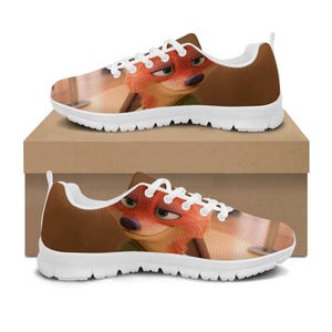 May include: Pair of trainers featuring a cartoon fox character. The shoes have a brown and white colour scheme, with the fox's face prominently displayed on the sides. The soles are white, and the trainers are sitting on a brown box.