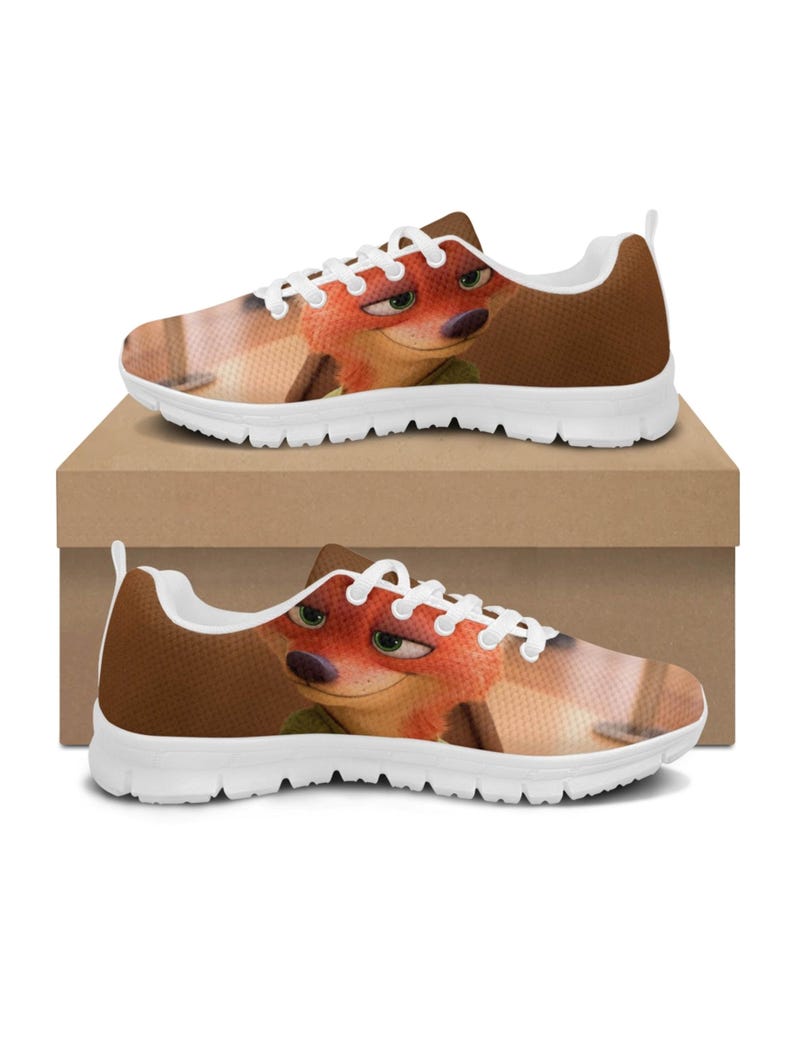 May include: Pair of trainers featuring a cartoon fox character. The shoes have a brown and white colour scheme, with the fox's face prominently displayed on the sides. The soles are white, and the trainers are sitting on a brown box.