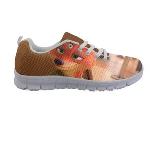 May include: Brown and white athletic shoe featuring a cartoon fox character. The shoe has a brown mesh upper, white laces, and a white sole. The fox character's face is visible on the side of the shoe.