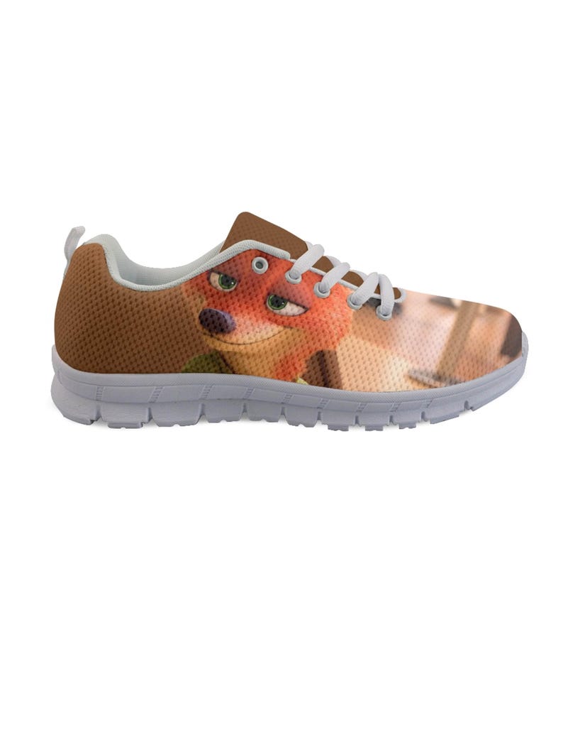 May include: Brown and white athletic shoe featuring a cartoon fox character. The shoe has a brown mesh upper, white laces, and a white sole. The fox character's face is visible on the side of the shoe.