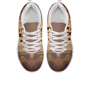 Pu&ograve; includere: Paio di scarpe sportive con un design artistico e colorato. Le scarpe hanno suola bianca, lacci bianchi e linguetta marrone. La parte superiore della scarpa mostra un design in stile paesaggio con toni caldi.