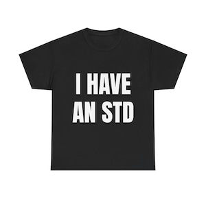 May include: Black t-shirt with the white text "I HAVE AN STD". The shirt is a crew neck style and appears to be made of a soft material. The text is centered on the front of the shirt.
