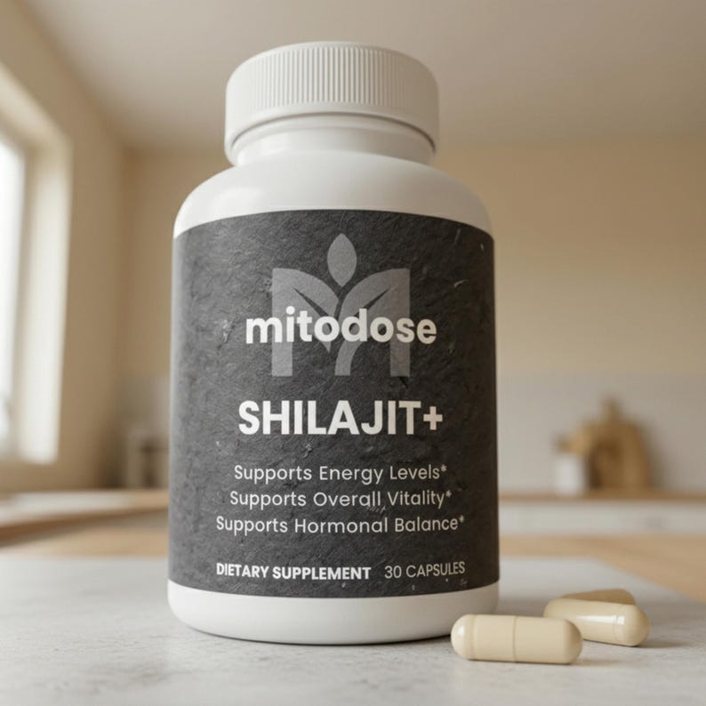 May include: A white bottle of "mitodose SHILAJIT+" dietary supplement with a black label. The label includes text that says "Supports Energy Levels", "Supports Overall Vitality", and "Supports Hormonal Balance". Two capsules are next to the bottle.