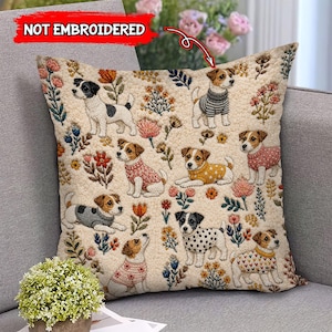 May include: A square throw pillow with a cream-coloured textured surface featuring a repeating pattern of Jack Russell terriers wearing various sweaters and surrounded by colourful floral illustrations. The text NOT EMBROIDERED is visible.