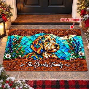 May include: A rectangular doormat featuring a colorful stained-glass style illustration of a dog. The design includes floral accents, Christmas ornaments, and the text "The Brooks Family" in white script. The mat has a 2D flat printed finish.