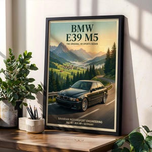 Może przedstawiać: Oprawiony plakat przedstawiający ciemnoszary sedan BMW E39 M5 jadący krętą drogą przez górski krajobraz. Tekst głosi BMW E39 M5 THE ORIGINAL V8 SPORTS SEDAN oraz BAVARIAN MOTORSPORT ENGINEERING S62 V8 400 HP GERMANY.