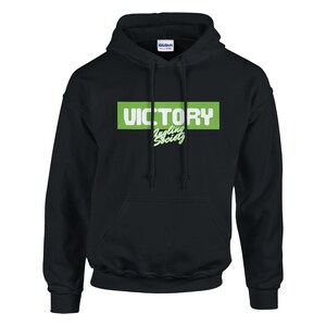 May include: Black hooded sweatshirt with a front pocket and drawstring. The front features the word "VICTORY" in white block letters inside a green rectangle, with "Juggling Society" in a script font below.