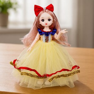 May include: A doll with long light pink hair, wearing a large red bow with a pearl accent. The doll features a yellow tulle skirt with a red ribbon and gold trim, paired with a blue and white bodice featuring red and gold decorative accents.