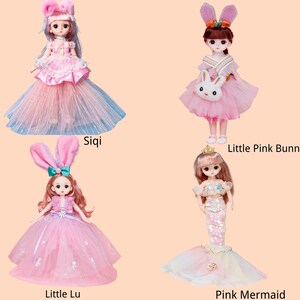 May include: Four dolls labeled Siqi, Little Pink Bunn, Little Lu, and Pink Mermaid. Siqi wears a pink and blue tulle gown. Little Pink Bunn has bunny ears and a rabbit bag. Little Lu features bunny ears and a pink dress. Pink Mermaid has a tail.
